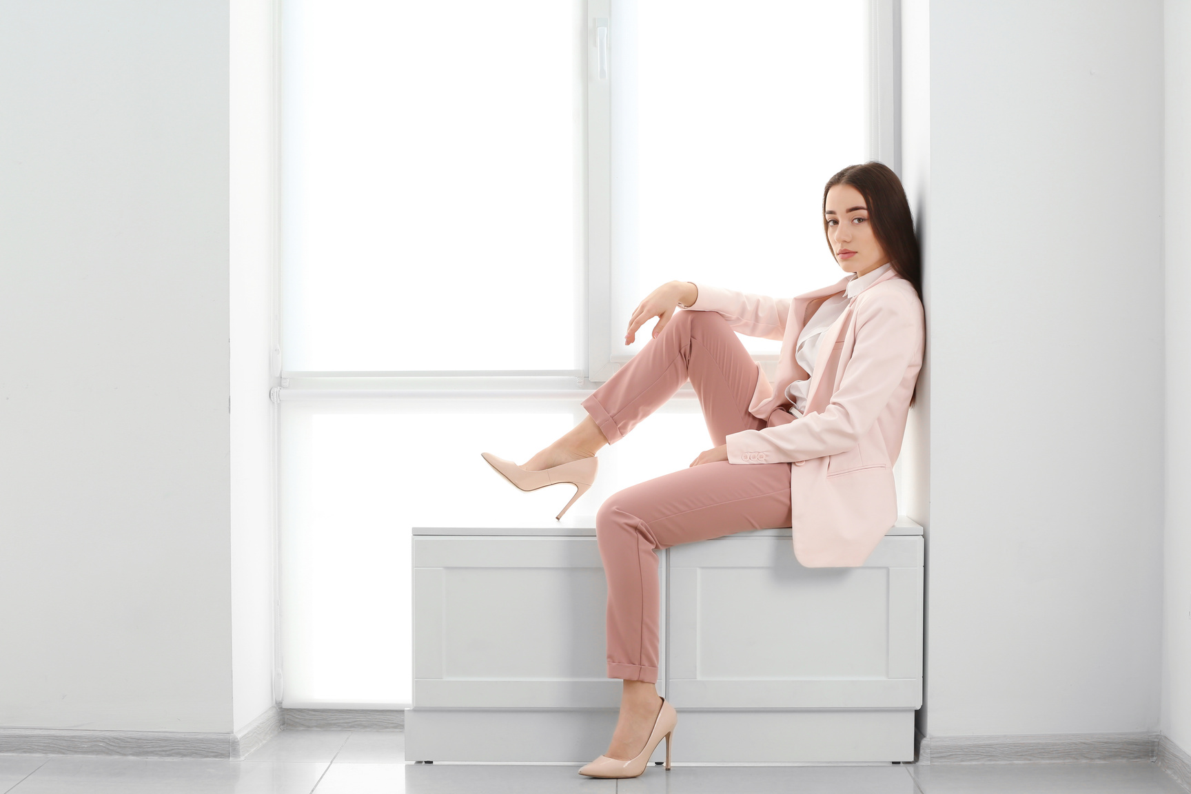 Beautiful Fashionable Woman in Elegant Suit near Window
